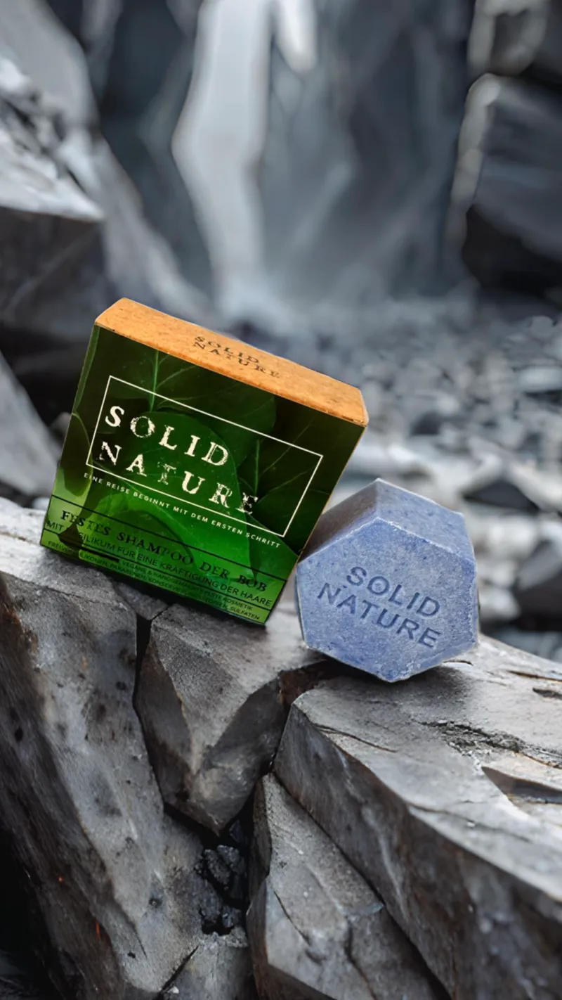 Festes Shampoo 'Der Bob' von SolidNature, stilvoll arrangiert auf einer felsigen Kulisse. Die Verpackung und das sechseckige feste Shampoo betonen Natürlichkeit, Stärke und Nachhaltigkeit in einer von der Natur inspirierten Umgebung.